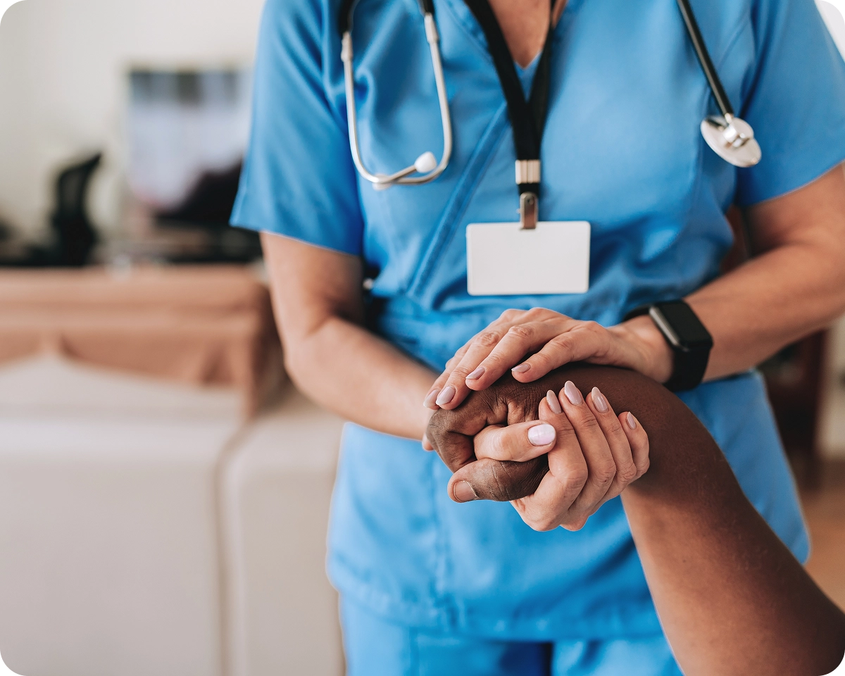Nurse comforting patient with supportive touch.