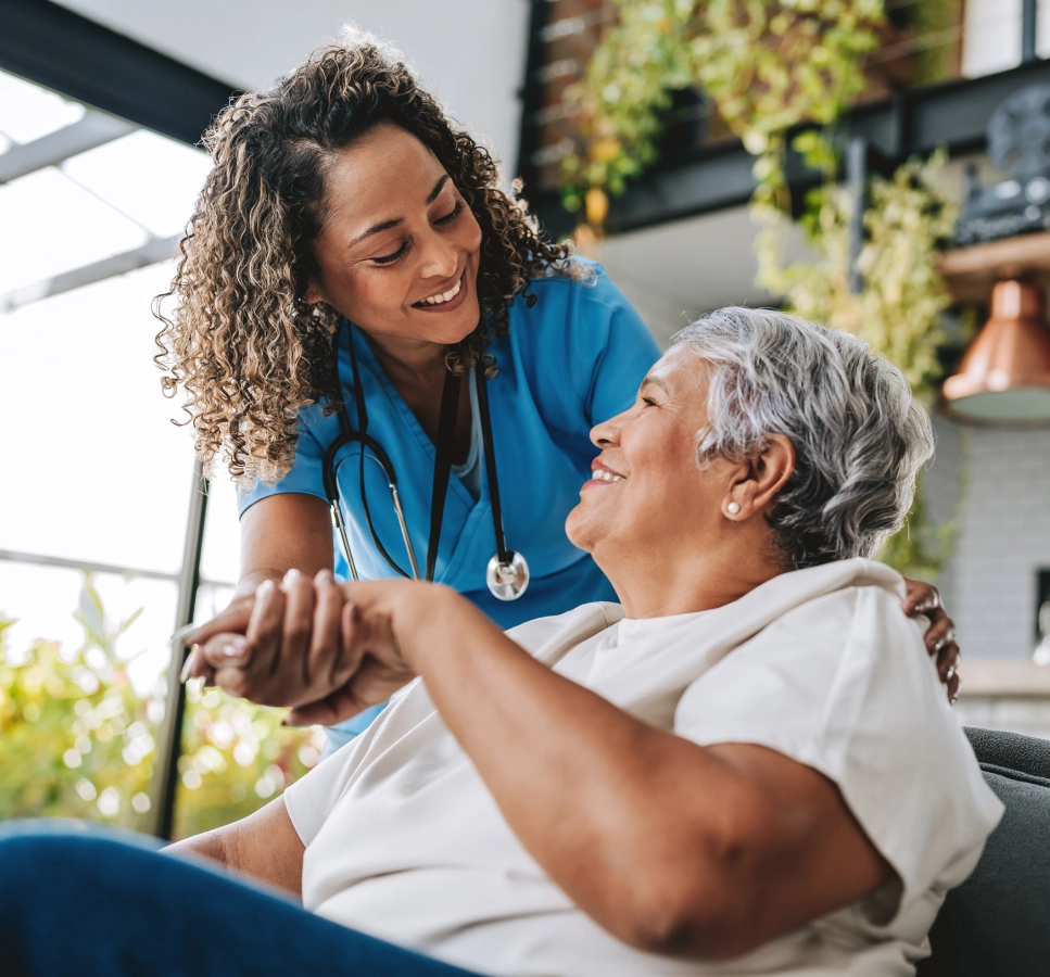 Nurse comforting elderly woman at home.