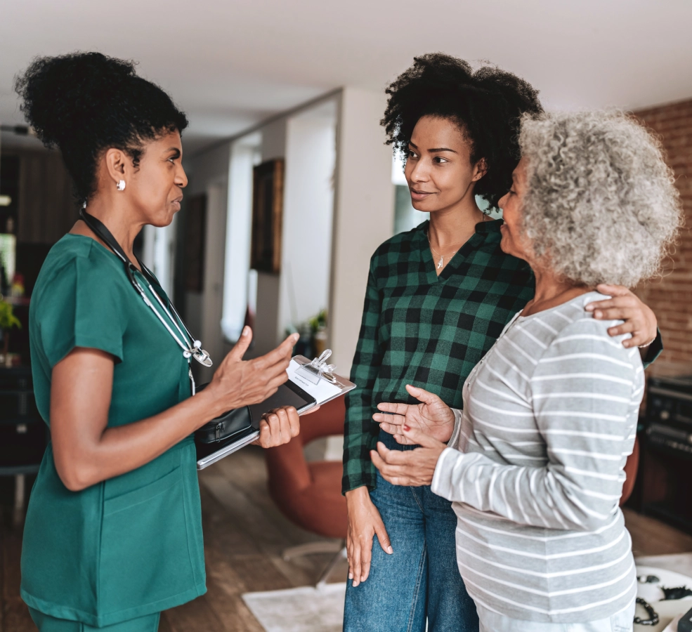 Doctor consulting with two women at home.