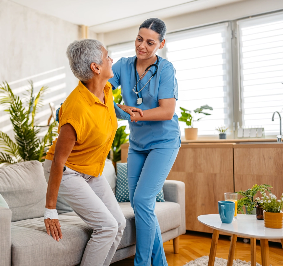 Nurse assisting elderly woman with exercises.